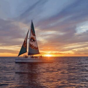 A sailboat on the ocean at sunset.